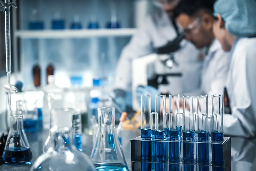 Chemists in a laboratory viewing through a microspoce