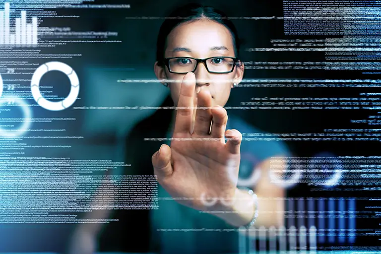 A woman wearing glasses interacts with a digital screen, showcasing her engagement with technology.
